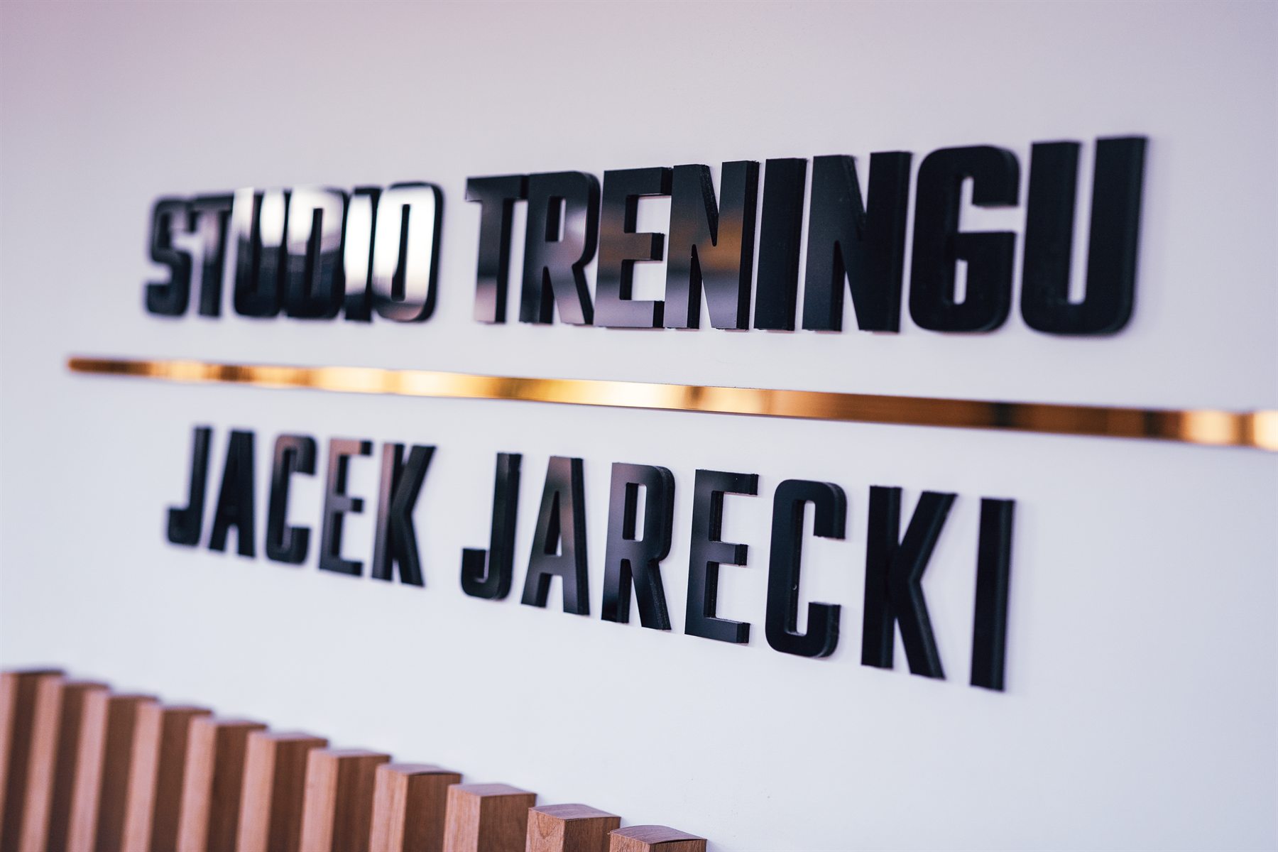 Logo Studio Treningu Jacek Jarecki na ścianie w studio